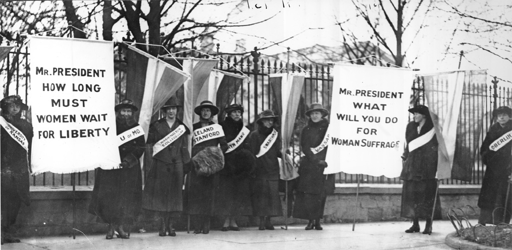 photo of college women picketing the White House, with sashes idntifying their institutions